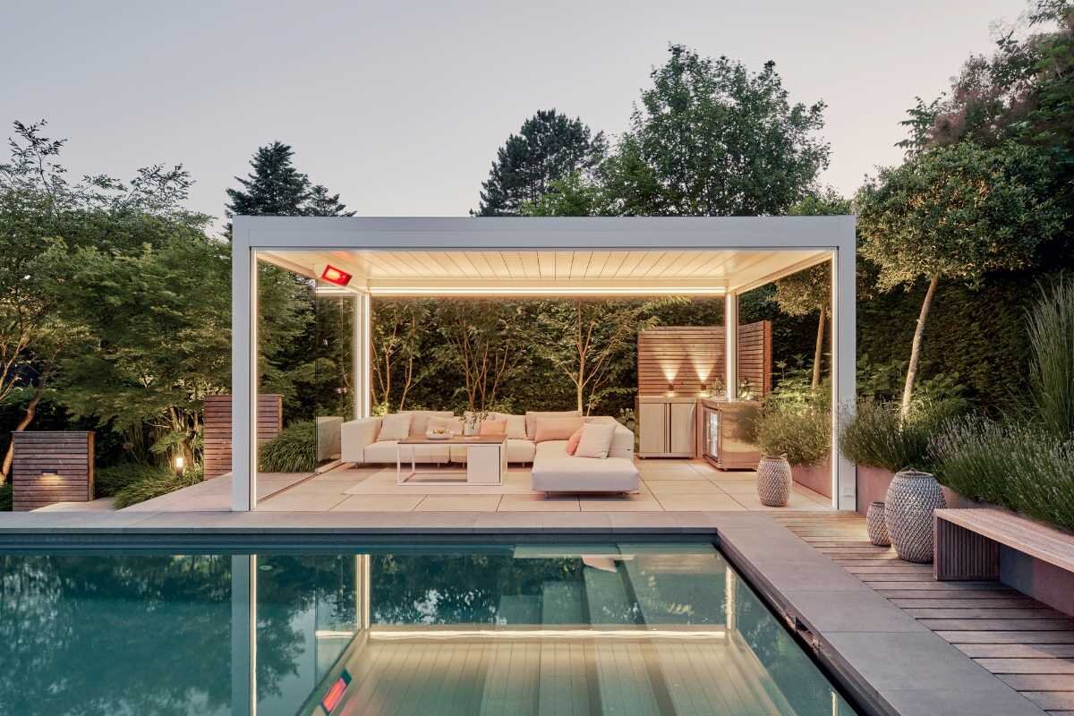 Gemütliche Terrasse mit Lamellendach und Pool Moderne Terrasse mit Pergola und Pool bei Sonnenuntergang
